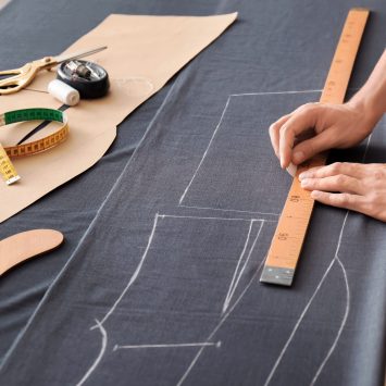 Young tailor working with textile in atelier