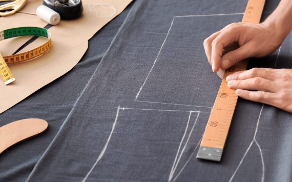 Young tailor working with textile in atelier